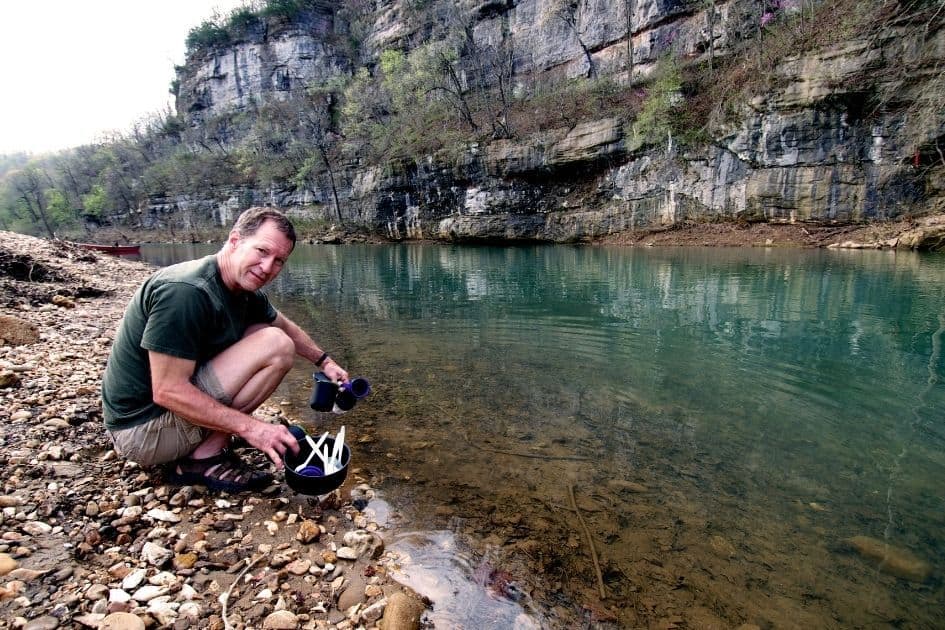 Washing dishes at camp kithcen sink campsite in river