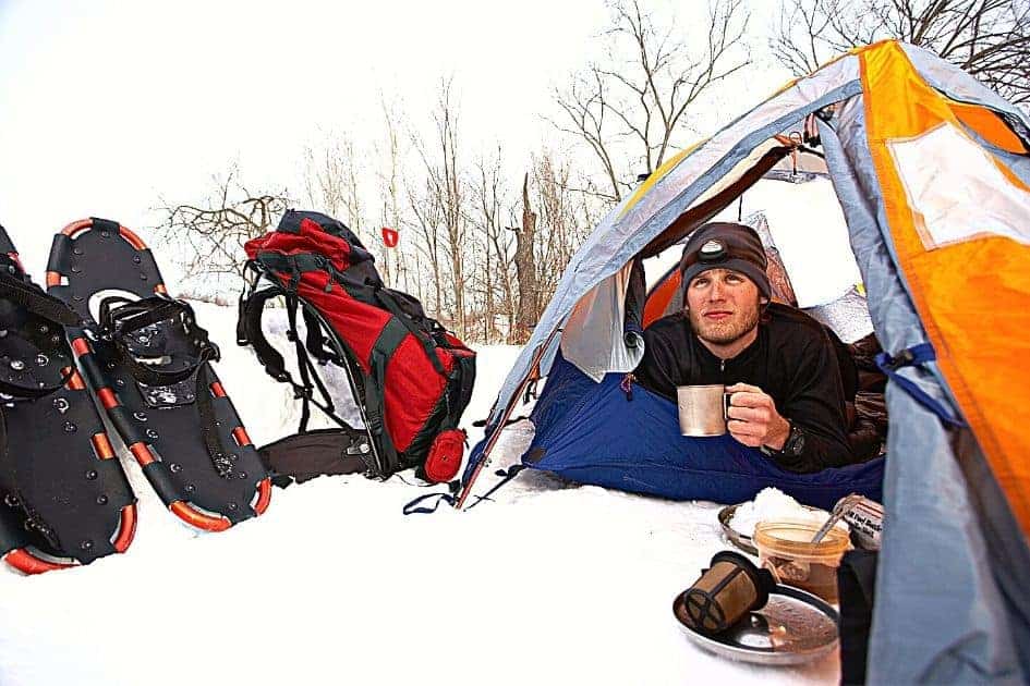 Camper drinking coffee inside four season tent