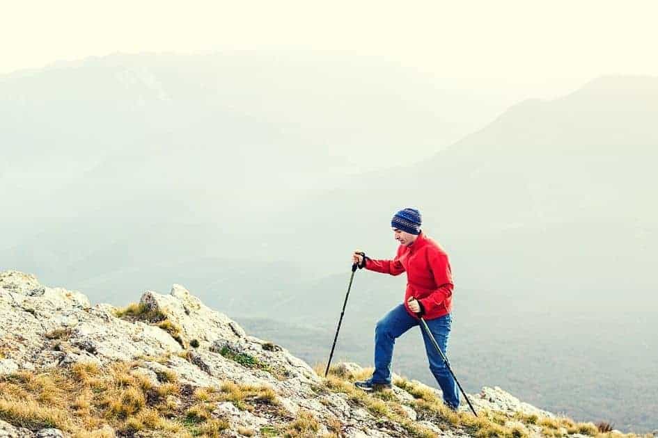 Hiker ascending mountain using hiking poles
