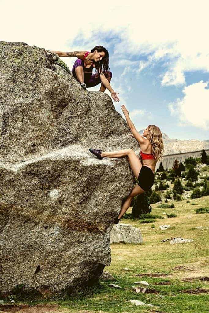 Friend lending a hand bouldering