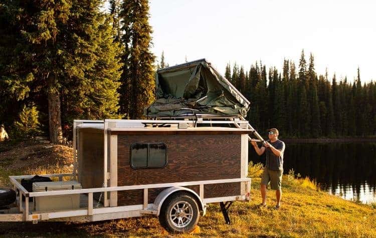 man assembling rooftop tent