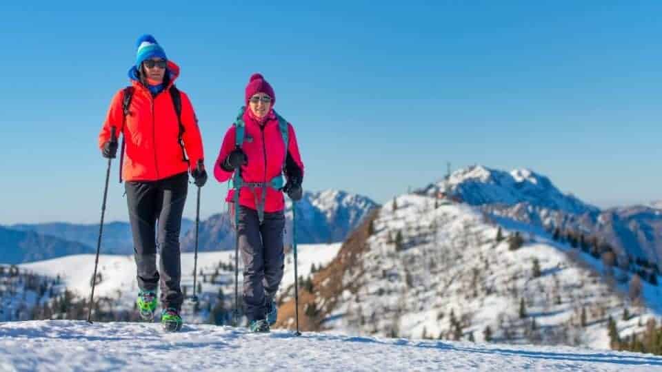 hiking with friends using trekking poles and crampons