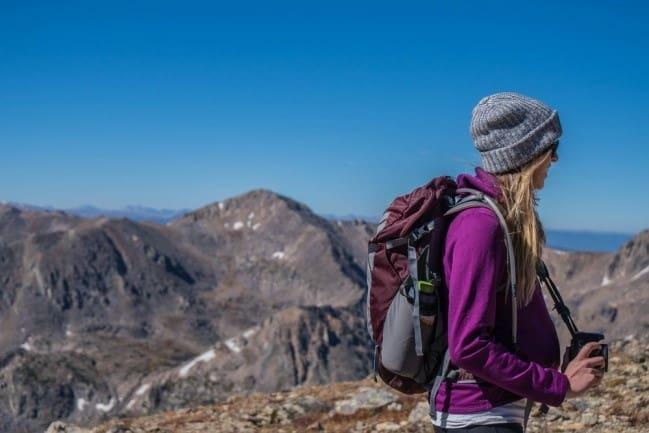 Woman with a camera hiking on mountain