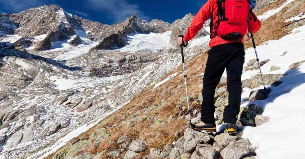 young male hiker while observing a high mountain panorama