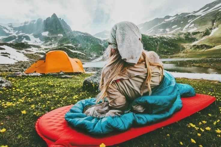 women enjoying the view while sitting in speeping bag