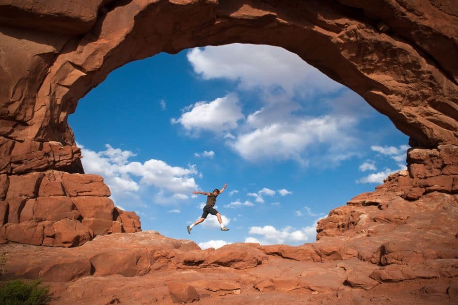 hiker jumping wearing hiking clothes